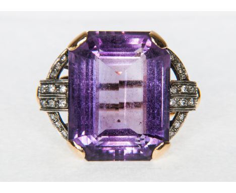 A large Amethyst dress ring, claw set in hallmarked 14 carat yellow and white gold and having diamonds, (12), eight cut stone