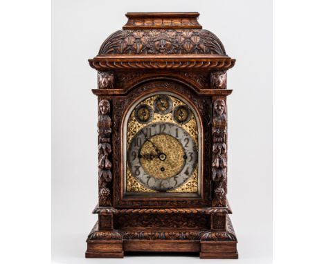 A Victorian carved oak mantel clock, arched gilt dial, silvered chapter ring with Arabic numerals, subsidiary dials, cast scr