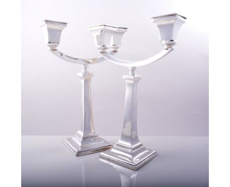Pair of silver two light candelabra, B*& Co., Birmingham 1934, sconces supported by open hoops, square tapering shafts and sq