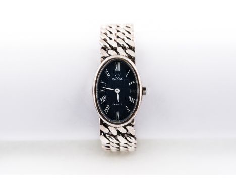 Omega - A lady's silver De Ville wrist watch having an oval dark blue roman numeral dial in a silver case with integral two r