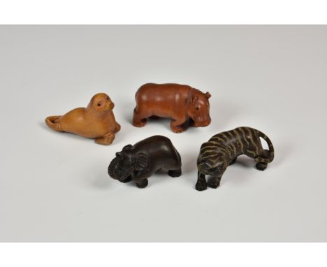 A group of four 20th century carved Japanese netsuke comprising a tiger, elephant, sea lion and hippo, each signed.