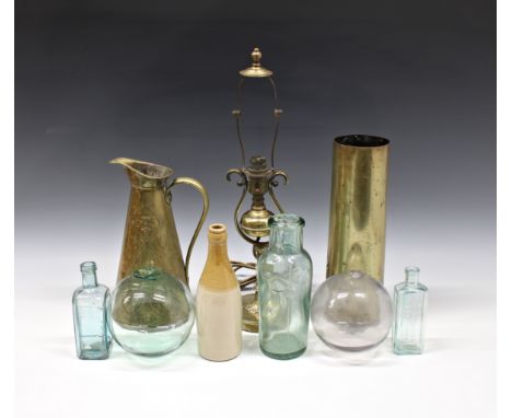 A collection of brassware and glass to include Art Nouveau brass jug; shell case; glass floats; bottles, lamp etc. (quantity)