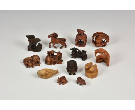 A collection of thirteen (13) 20th century carved Japanese netsuke of varying forms to include monkeys on horse; owl; pigs, e