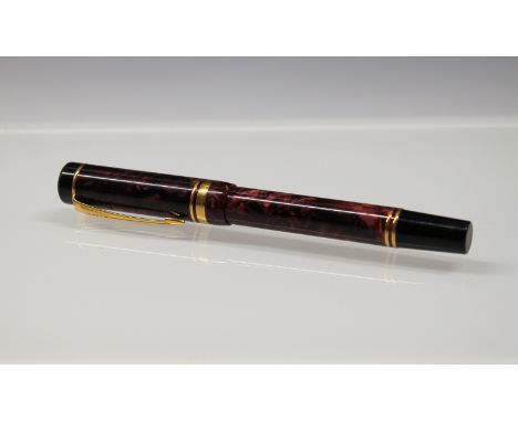 Parker - a Duofold red marbled fountain pen the cap with gilt arrow clip and double band, nib stamped 18k 750, cartridge fill