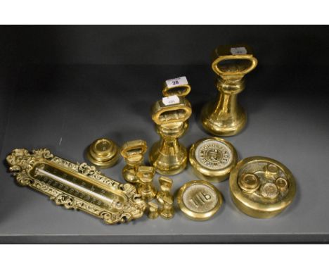 An assorted collection of brassware, including bell weights and a thermometer
