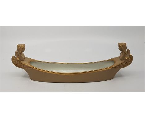 A ceramic boat form pen tray,&nbsp;in the manner of Coalport, with gilt winged figure head to either end, length 32.8cm&nbsp;