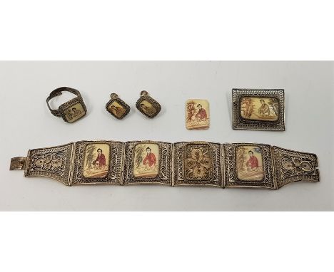 A Chinese white metal plated filigree work bracelet, brooch, ring and earrings en suite, each having simulated ivory panel/s 