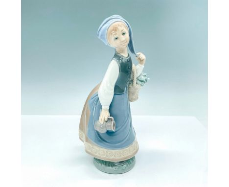 Lovely, glazed figurine of a daydreaming woman twirling her head scarf with a basket and pitcher in her hand. Crafted in subt