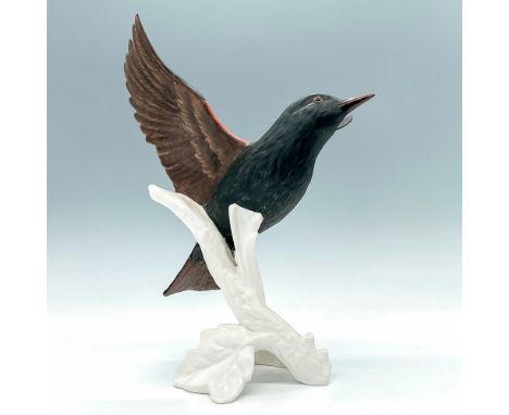 Depicts a matte black bird with yellow and red accents about to fly away on a white glossy branch. Goebel backstamp and stick