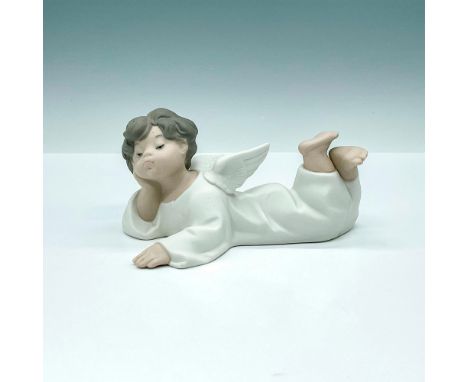 Captivating matte finished figurine of young angel laying on the floor with bored look on his cherub looking face. Crafted in