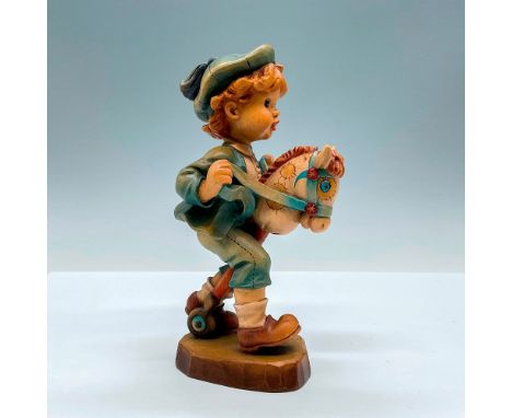 Sweet painted figure of a young lad riding his stick horse. In hues of earthy blue, red, tan and brown. Anri metal logo emble