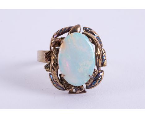 A 14k yellow gold ornately designed ring set with an oval cabochon cut opal, measuring approx. 14.5mm x 10mm , 4.97gm, size M