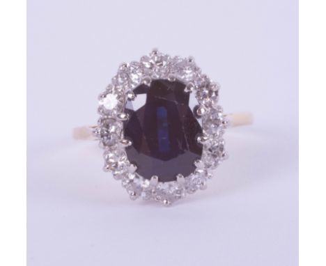 An 18ct white and yellow gold oval sapphire and diamond cluster ring, size K.