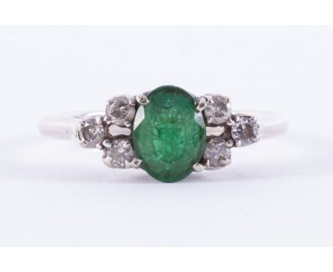 A white gold ring (no hallmarks &amp; not tested) set with a central oval cut emerald, approx.0.94 carats, with a trefoil of 