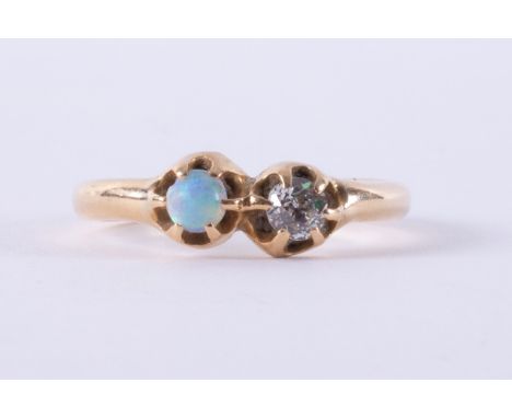 A yellow gold antique ring set with a cabochon cut opal measuring approx. 3.5mm and an old round cut diamond, approx. 0.17 ca