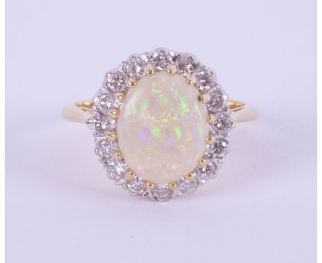 An 18ct white and yellow gold oval opal and diamond cluster ring, size P.