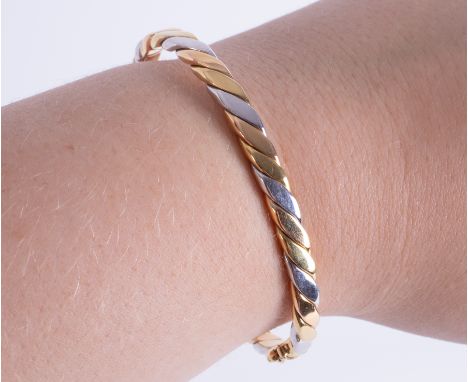 An 18ct yellow, white &amp; rose gold twist design hinged bangle with push in clasp &amp; figure of eight safety catch, 19.58