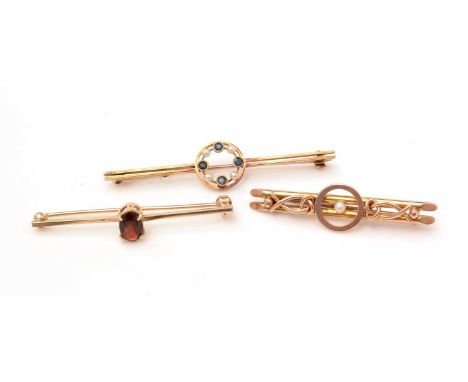 A sapphire and seed pearl bar brooch, stamped '15ct'; a 9ct yellow gold and garnet bar brooch; and a seed pearl bar brooch st