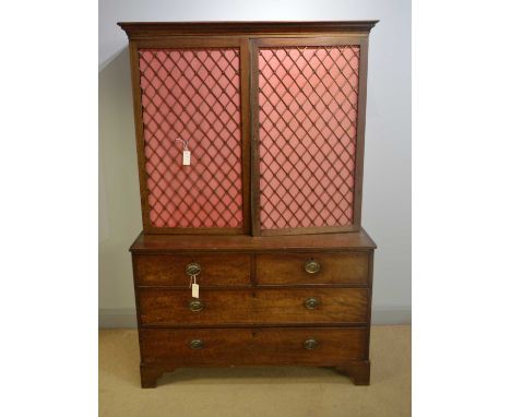 A 19th Century mahogany cabinet on chest, cavetto cornice above a pair of brass grill doors with woven pink backing, shelved 