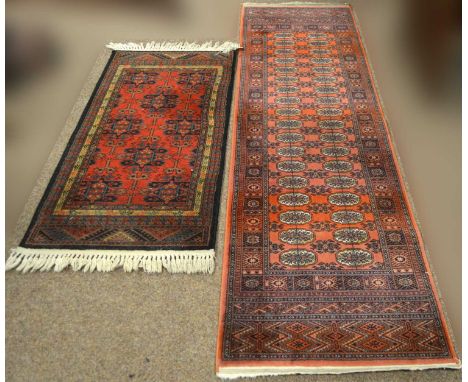 A handmade topaz runner, in the Turkoman style, made in Belgium, 238 x 68cms; and a handmade Shiraz pattern rug, 138 x 66cms.
