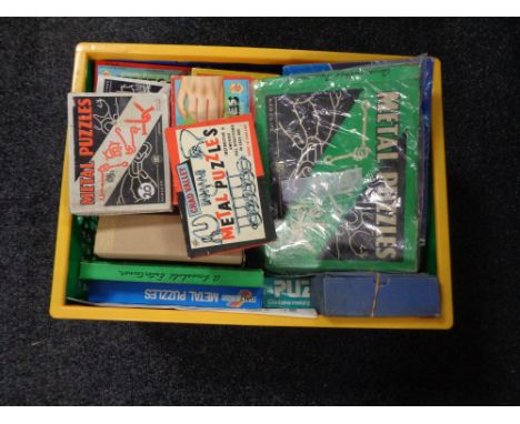A basket containing vintage and later metal puzzles. 