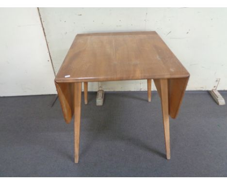 An Ercol elm and beech flap sided dining table 