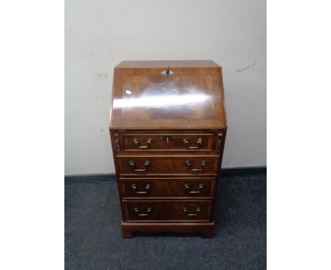 An inlaid mahogany writing bureau, fitted four drawers on bracket feet.  