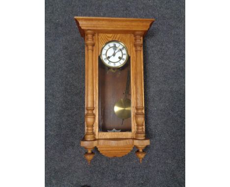 A 20th century oak wall clock with brass and enamel dial. 