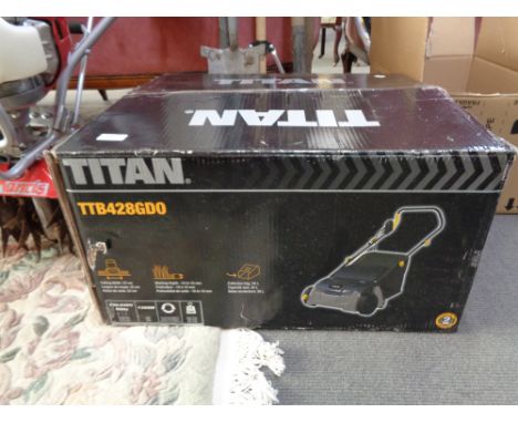 A boxed Titan lawn scarifier together with Titan pole saw attachments and a bundle of garden tools.   