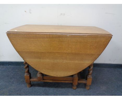 An Edwardian oak barley twist gate leg table. 