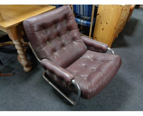 A 20th century Burgundy button leather and tubular metal armchair.  CONDITION REPORT: width 76 cm, areas of wear and pretty d