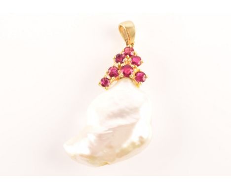 An 18ct yellow gold keshi pearl and ruby pendant, set with a baroque pearl measuring approximately 2 cm length x 1.5 cm width