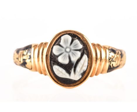 A Victorian mourning ring, yellow gold with black enamel detail, set to centre with a forget me not cameo, inscribed to inter