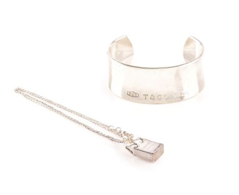 A Tiffany &amp; Co. sterling silver wide cuff bangle, diameter 6.5cm, along with a silver Tiffany &amp; Co shopping bag charm