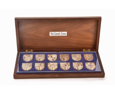 A collection of twelve silver ingots, of the Royal Coats of Arms, shield shaped in a bespoke fitted wooden box.  Condition Re