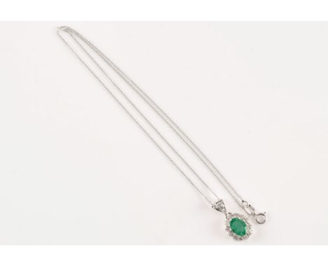 An 18ct white gold emerald and diamond pendant and chain, featuring a oval cut emerald with an approximate weight of 0.80 car