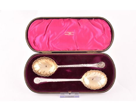 A pair of Edward VII silver and gilt fruit serving spoons, hallmarked Sheffield 1910 by Walker &amp; Hall,&nbsp;with a shell 