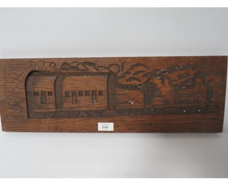 A VINTAGE CARVED WOOD PANEL DEPICTING A STEAM ENGINE AND CARRIAGES EMERGING FROM A TUNNEL