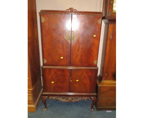 A MAHOGANY CARVED DRINKS CABINET ON CABRIOLE LEGS