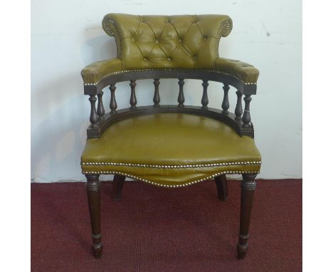 A Captain's chair, with studded button back leather upholstery, on turned legs 