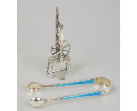 A pair of sugar tongs, with blue enamel handles, white metal stamped 925, and a miniature spinning wheel, stamped 925.