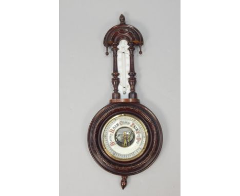 A late 19thC walnut aneroid barometer/thermometer, in a carved case