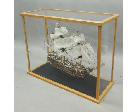 A scale model three masted ship, fully ridged, etc., in a light oak glaze case, 112cm wide. 