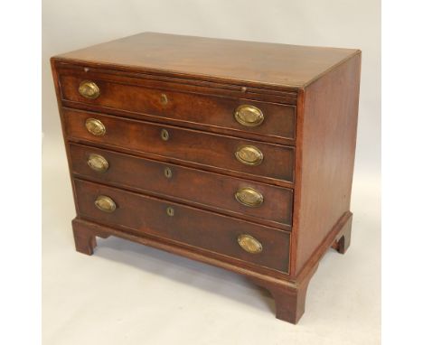 A George III mahogany chest of drawers, with a caddy top above a brushing slide, and four graduated drawers, with later oval 