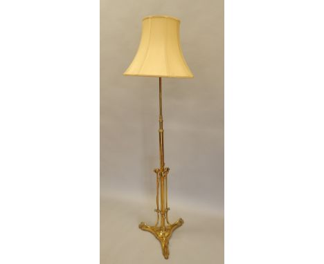 A late 19thC / early 20thC adjustable brass Art Nouveau style floor lamp, with cream shade, 190cm high.