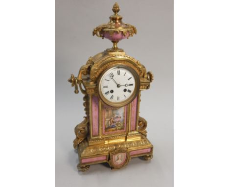 A 19thC French gilt metal and porcelain mounted mantel clock, the top applied with an urn above a white enamel dial, the move