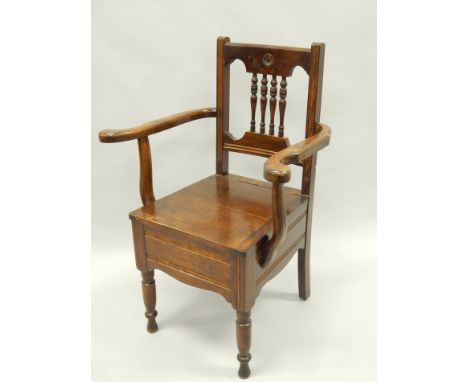 An early 20thC stained wood commode chair, on turned legs (AF). Provenance: Thurlby Hall, Lincolnshire