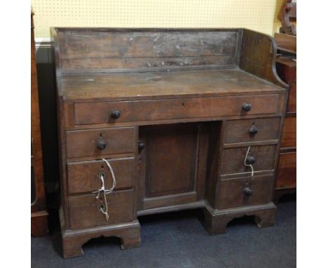 A late 18th/early 19thC estate made oak kneehole dressing table, with a raised back, above one long frieze drawer and a panel