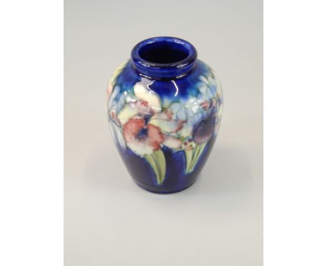 A Moorcroft ceramic vase, decorated with a band of Iris's on a blue ground, hand written and impressed mark to underside, 17c