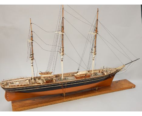 A scale model of a 19thC three masted sailing ship, on an oak base, 110cm wide